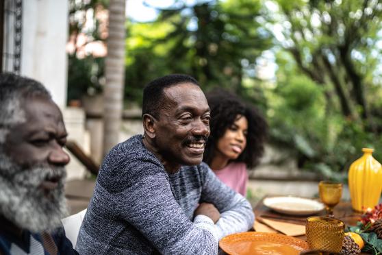 A family sitting at a table with plates and glasses