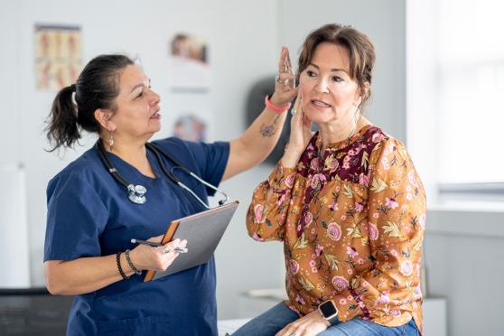 A health professional checking a patients ear