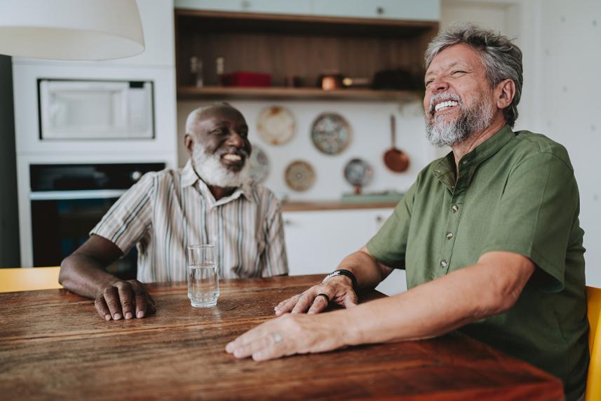 Two men laughing at a dining room table