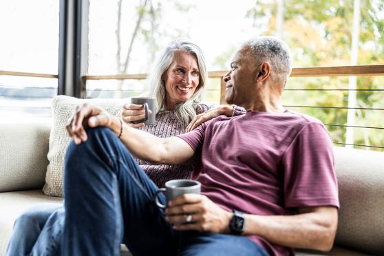 A couple sitting on a couch and smiling at each other
