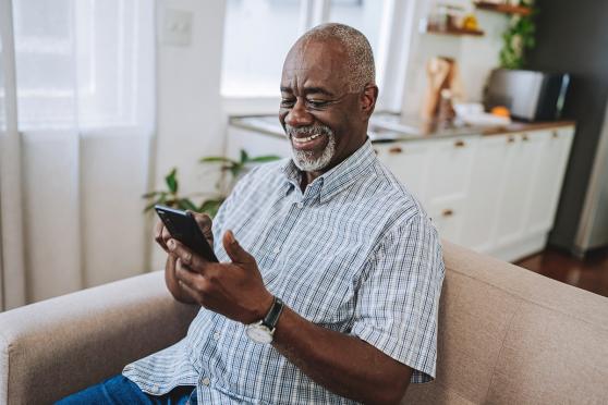 A man smiling at his phone